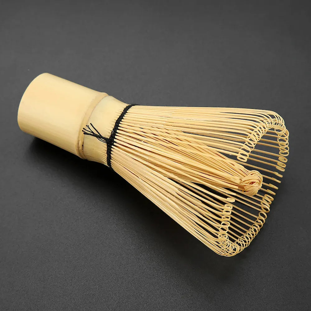 Authentic bamboo matcha whisk on a dark background, ideal for preparing smooth, frothy matcha.